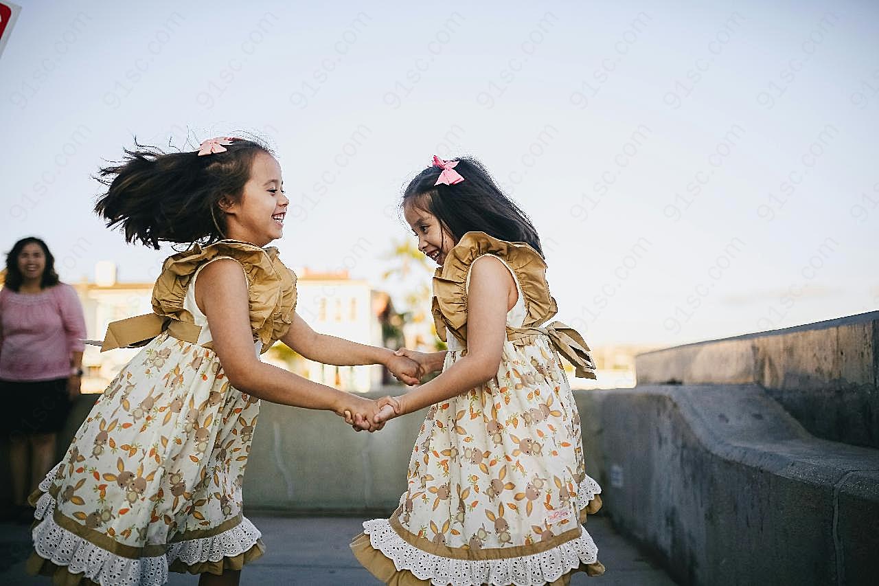手拉手开心跳舞的两女孩图片高清