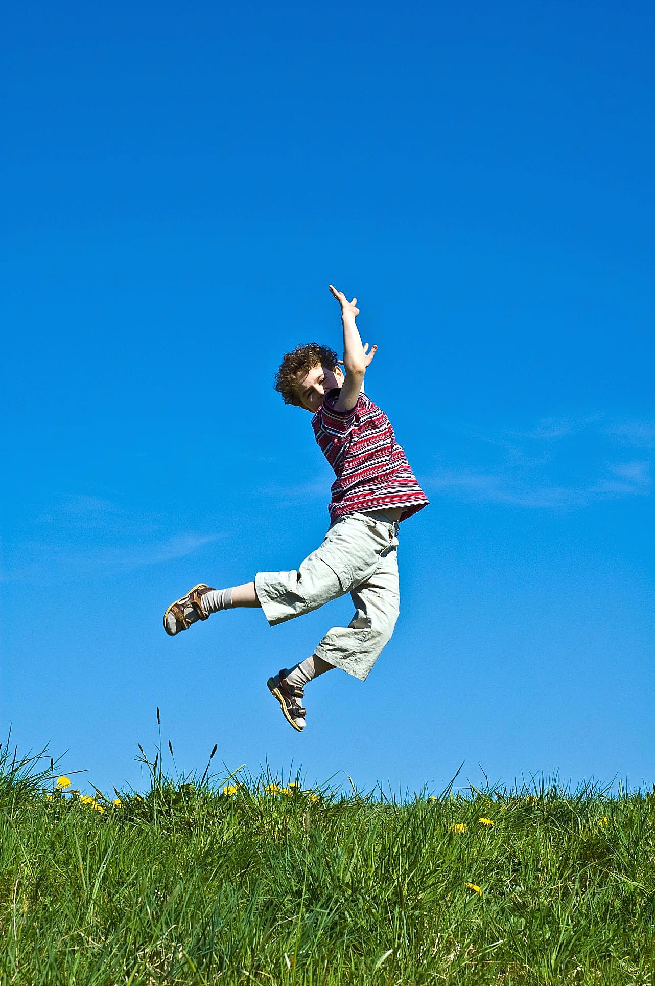 草地跳跃的小孩高清摄影