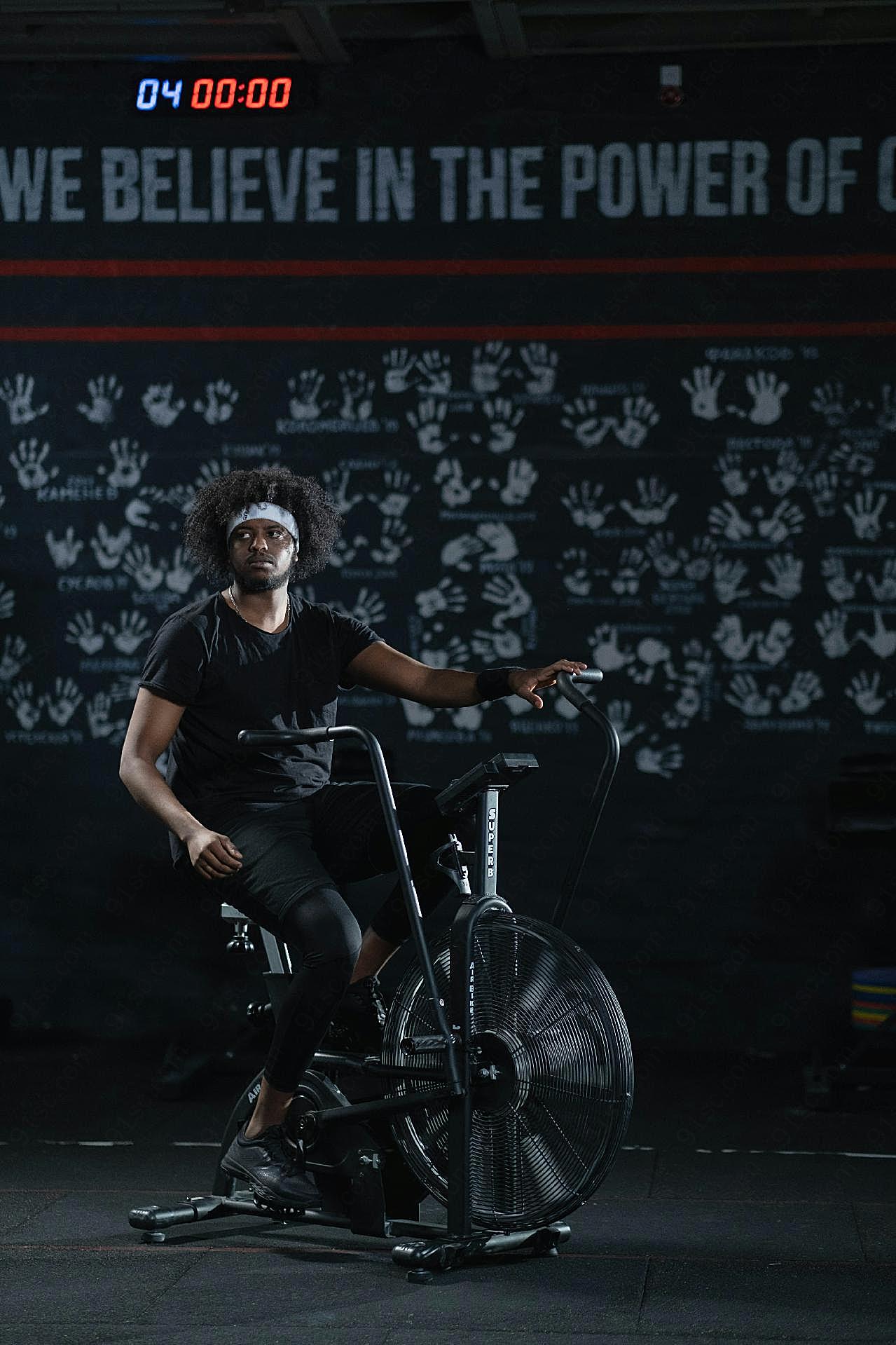 男人做有氧脚踏车运动图片摄影